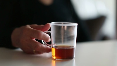 一位面目全非的老妇人喝着一杯茶
