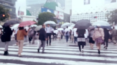下雨时穿过城市道路的人群