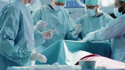 由专业外科医生、助理和护士组成的不同团队在医院手术室对病人进行侵入性手术。真正的现代化医院，有真正的设备。