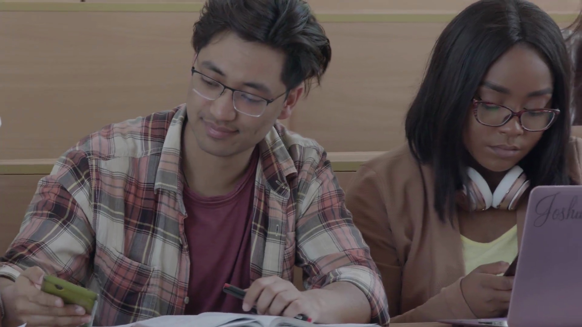不同国籍的学生都在使用笔记本电脑学习。