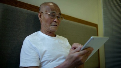 亚洲老年人在室内使用数字平板电脑