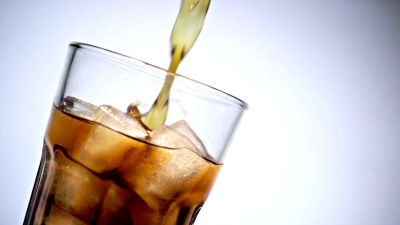 将可乐倒入加冰的玻璃杯中
