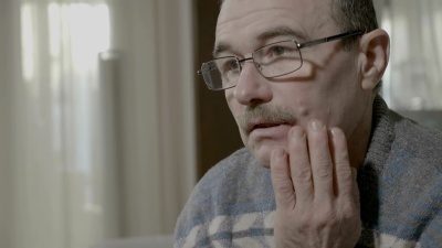 一位年长的男子患有强烈的牙痛，揉着他的脸颊感觉很不好