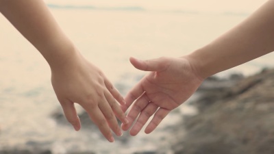 慢动作情侣男女在沙滩上手牵手感受温暖。浪漫和爱。作为背景情人节概念与复制空间为您的文本或设计。