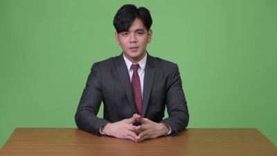 绿色背景下年轻英俊的亚洲商人