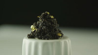 专业厨师在豪华餐厅用金色装饰黑鱼子酱