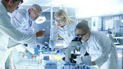 医学研究科学家团队致力于新一代疾病的治疗。他们使用显微镜，试管，微量吸管和写下分析结果。实验室看起来忙碌，明亮和现代。