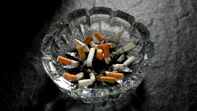 在烟灰缸中用手推着点燃的烟头的慢动作镜头