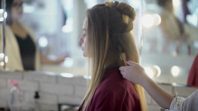 女发型师在美容院的发型上使用发胶