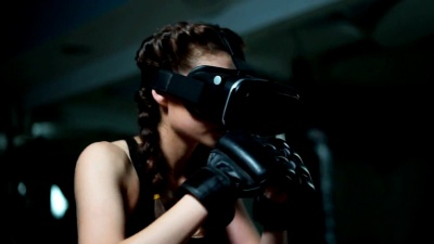 年轻迷人的女子拳击在VR 360头戴式耳机训练踢在虚拟现实。慢镜头