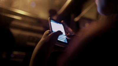 女孩晚上在车里用智能手机发短信