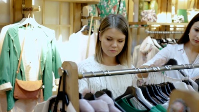 女性朋友在精品店挑选衣服