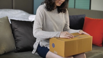女人坐在沙发上打开纸板箱