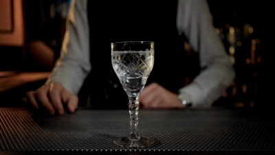 调酒师在干马提尼鸡尾酒中加入橄榄