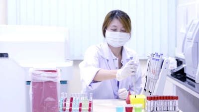 女孩在充满样品的实验室吸管中。