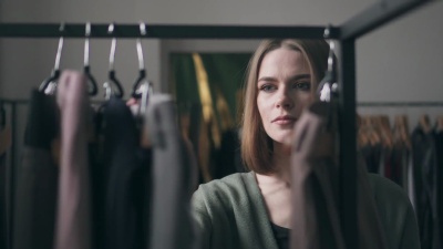 年轻女子在衣架上挑选衣服