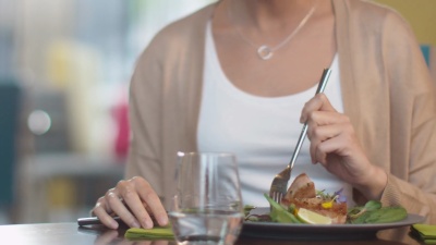 迷人的年轻女子在豪华餐厅享用鱼排