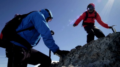 登山者在山上的岩石上互相帮助