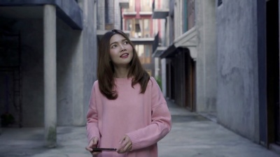 慢动作-年轻的亚洲博主女性在城市中行走，美丽的旅游女性在假日使用智能手机拍照。生活方式女性放松在城市的概念。