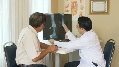 医生正在给病人看X光片，并向病人解释