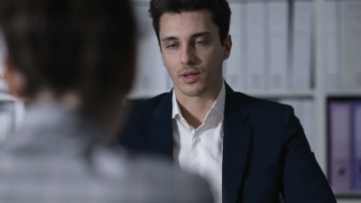 业务主管在办公室开会，他正在与客户交谈并给客户一份合同
