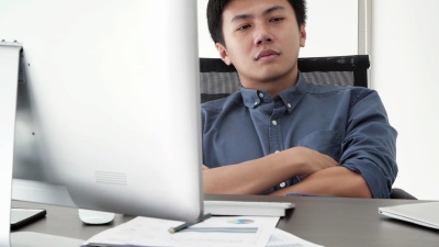 坐着工作时睡得很累的人。疲倦而有压力的商人工作到深夜