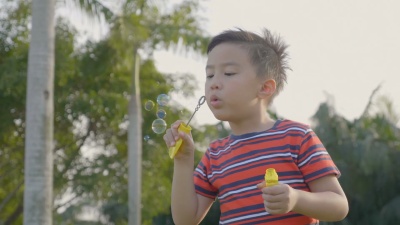 可爱的小男孩在慢动作中玩泡泡。