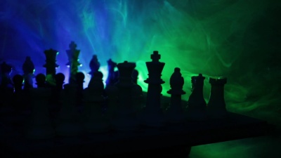 滑杆射击。棋盘游戏理念的经营理念和竞争理念和战略理念。在烟雾弥漫的黑暗背景下的国际象棋人物。旋转棋盘。选择性聚焦