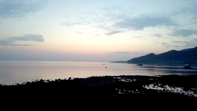 夕阳下的石质海岸和群山。印度尼西亚。Bali.无人机俯瞰