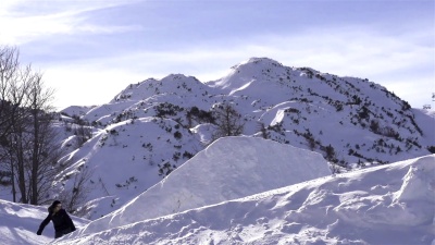 慢动作 滑雪者女孩跳过踢球人