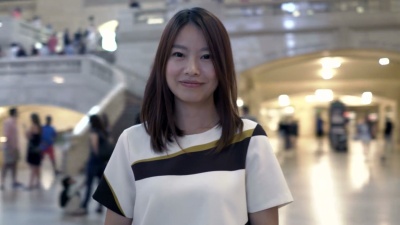 漂亮的亚洲女孩使用发送短信和快乐在一个大城市。好天气，阳光明媚的日子。