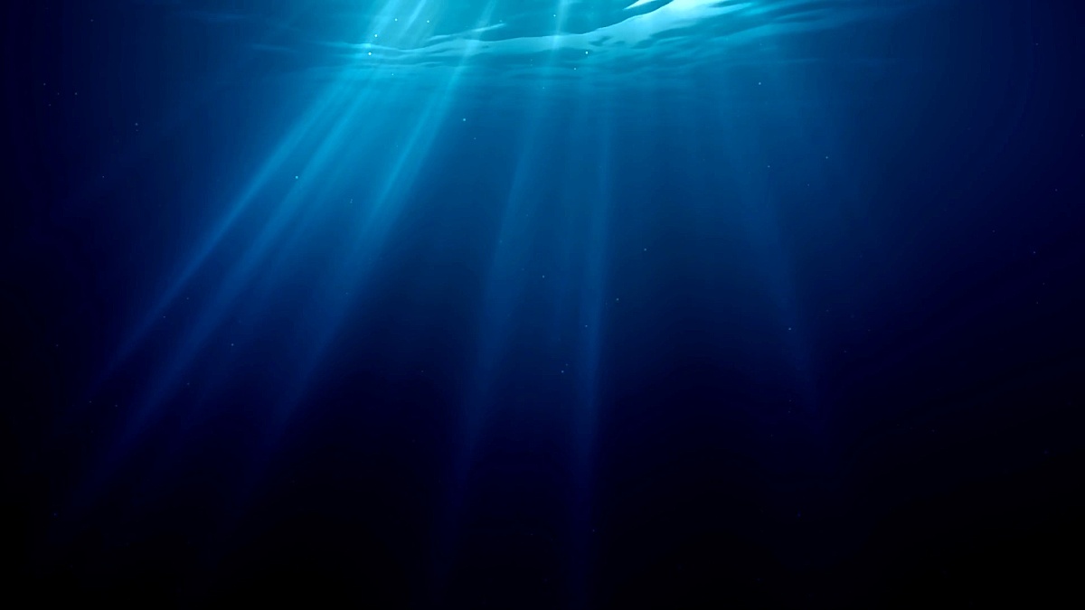 Sunlight rays shining through ocean surface. View from underwater. 3D rendered seamless loop animation.