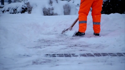 工人们在冬天清扫道路上的积雪。从暴风雪中清理城市