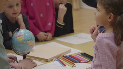   幼儿教师和儿童在课堂上学习地理。