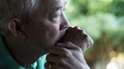 亚洲资深男子，手放在脸上，思考