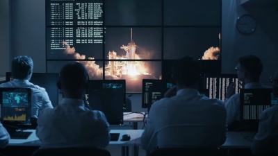 任务控制中心的一群人挤满了显示器，庆祝火箭发射成功。这张图片的元素由NASA提供