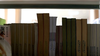 中国女学生在图书馆的书架上实时找书。