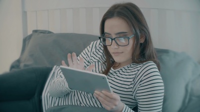 家里的数字平板电脑。戴眼镜的年轻女子。