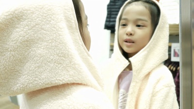 亚洲女孩在镜子前试衣的乐趣