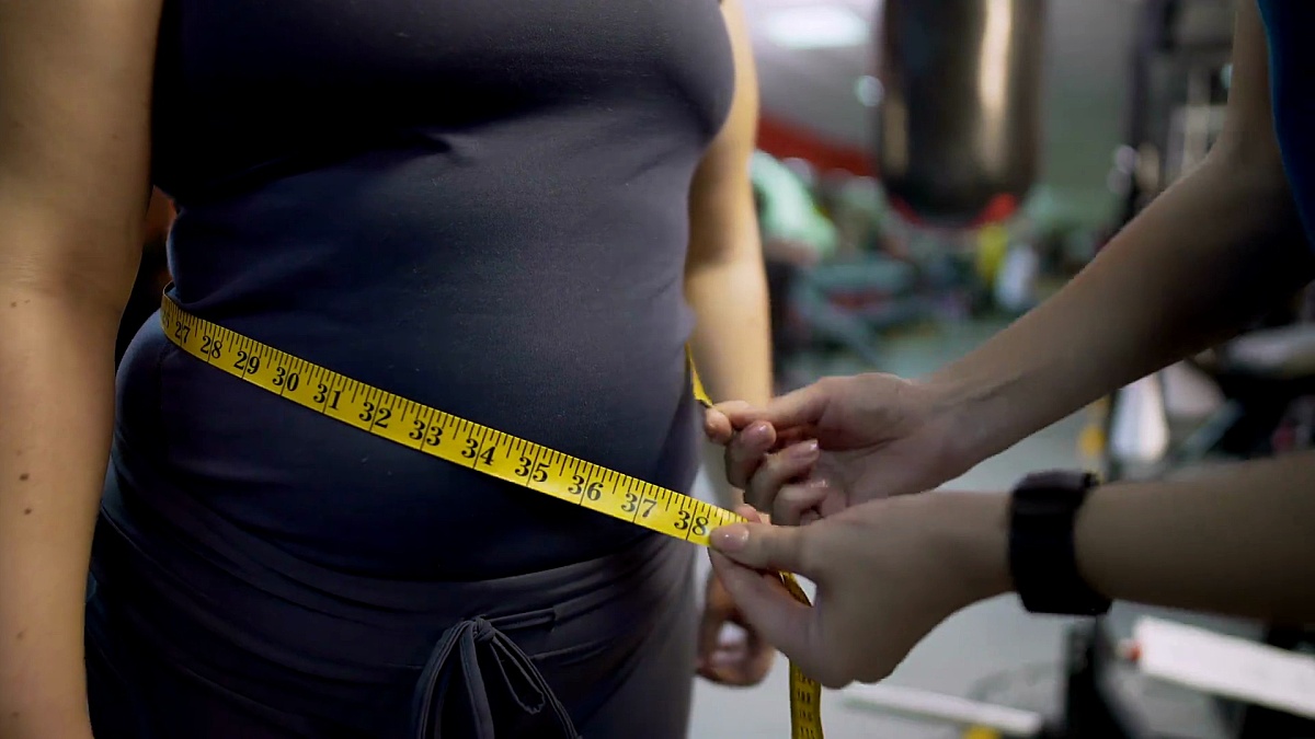 健身教练测量女性腹部健康饮食和锻炼结果控制