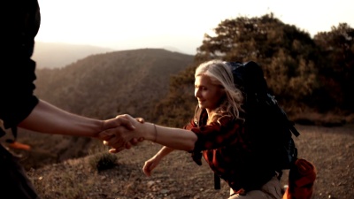 老年女性徒步旅行者手牵手爬山