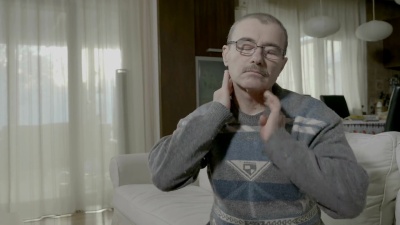 退休后疼痛的男子在家中按摩颈背以治疗肌肉拉伤的疼痛