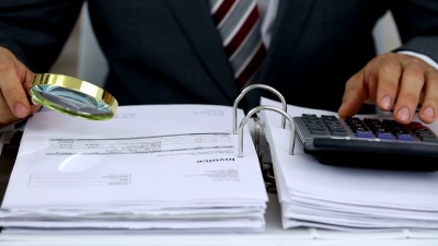 商人用放大镜审阅发票