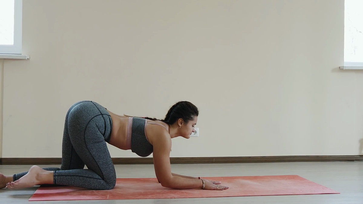 健身女性在运动垫上做伸展运动。年轻女子在室内健身垫上锻炼