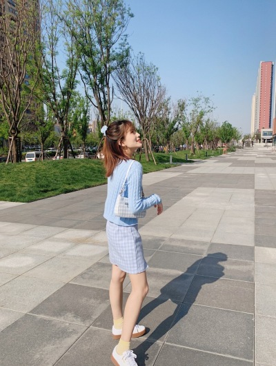 服饰系列实景模特穿着蓝色针织上衣和蓝色短裙的街头摆拍