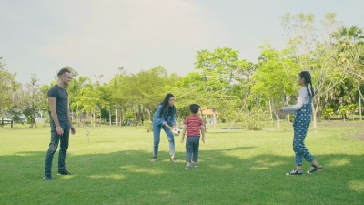 孩子和父母在公园里踢足球。慢动作。