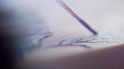 使用小画笔将油画涂到画布上的艺术家特写