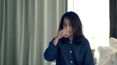 亚洲妇女在床上喝水
