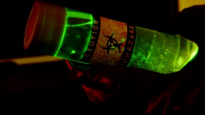 生物危害技术持有一小瓶发光的绿色液体