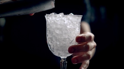 酒保做红冰鸡尾酒。他把红酒倒进杯子里